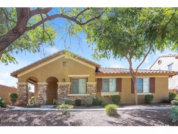 Inviting single-story home featuring stone accents, desert landscaping, and a welcoming covered entryway at 2475 E Vermont Dr, Gilbert, AZ 85295