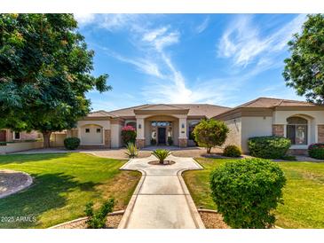 Beautiful single-story home featuring lush landscaping, a paved walkway, and a welcoming entrance at 320 N Portland Ave, Gilbert, AZ 85234