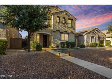 Charming two-story home with a desert landscape and illuminated pathway to the front door at 3476 E Orchid Ln, Gilbert, AZ 85296
