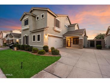 Two-story home showcasing a well-manicured lawn, neutral paint, and a two car garage with driveway under a colorful sky at 3932 S Crosscreek Dr, Chandler, AZ 85286