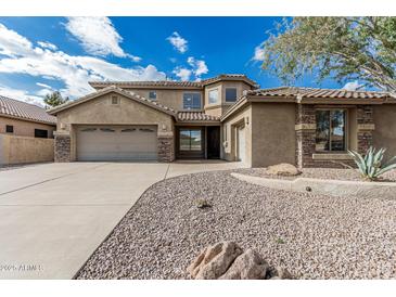 Charming home featuring a spacious three-car garage, stone accents, desert landscaping, and tile roof at 4336 W Hackamore Dr, Phoenix, AZ 85083