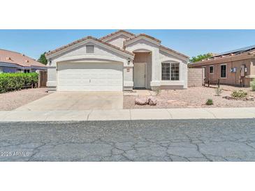 Charming single-story home featuring a stucco exterior, a two-car garage and low maintenance desert landscaping at 11154 W Ashley Chantil Dr, Surprise, AZ 85378