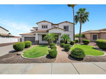 Beautiful two-story home with lush landscaping, a brick walkway, and a three car garage at 18429 W Mauna Loa Ln, Surprise, AZ 85388