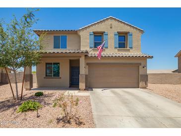 Two-story home with tan stucco, blue shutters, landscaping and an American flag at 21648 W Ashleigh Marie St, Buckeye, AZ 85326