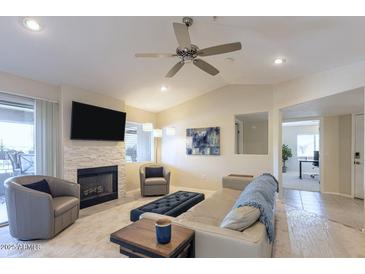 Bright living room with fireplace, ceiling fan, and neutral decor for a relaxing atmosphere at 9745 N 95Th St # 227, Scottsdale, AZ 85258
