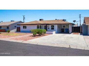 Charming single-story home with a spacious driveway, well-maintained lawn, and desert landscaping at 1011 W Weldon Ave, Phoenix, AZ 85013
