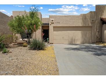 Charming single-story home featuring a well-maintained yard, two-car garage, and desert landscaping at 11762 E Becker Ln, Scottsdale, AZ 85259