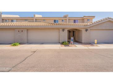 Inviting townhouse exterior with desert landscaping, garage, and covered entryway with block wall construction at 16021 N 30Th St # 122, Phoenix, AZ 85032