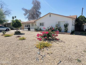 Charming single-story home featuring vibrant desert landscaping and a covered carport at 2115 W Myrtle Ave, Phoenix, AZ 85021