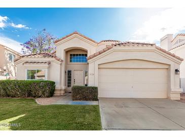 Inviting single-story home featuring a well-maintained front yard and a two-car garage at 2134 W Peninsula Cir, Chandler, AZ 85248
