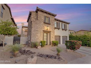 Charming two-story home with stone accents, two-car garage, and desert landscaping in the front yard at 22317 N 39Th Run, Phoenix, AZ 85050
