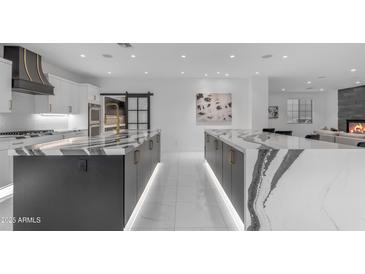 Gourmet kitchen with double islands, high-end appliances, custom hood, and an open layout for seamless entertaining at 22317 N 39Th Run, Phoenix, AZ 85050