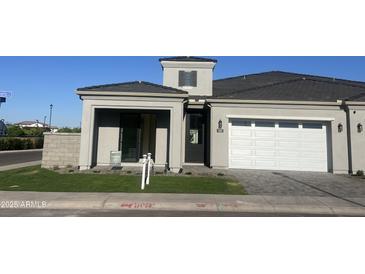New home with a modern design, two car garage, beautiful lawn and desert landscaping in front at 3332 S Quinn Ave, Gilbert, AZ 85297