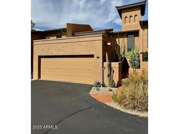 Desert home with a tan stucco exterior, a two car garage and drought-resistant landscaping at 7432 E Hum Rd # 203, Carefree, AZ 85377