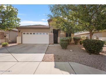 Charming single-story home with a well-manicured front yard and a two-car garage at 7818 S 74Th Ave, Laveen, AZ 85339