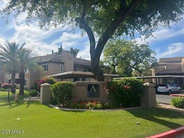 Charming condo complex with lush landscaping and mature shade trees on a partly cloudy day at 9450 E Becker Ln # 2051, Scottsdale, AZ 85260
