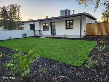 Landscaped backyard featuring new turf, fresh mulch, and a privacy fence at 954 E Henry St, Tempe, AZ 85288