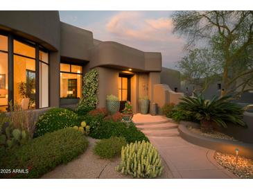 Inviting front entrance with desert landscaping, warm lighting, and a charming southwestern architectural design at 10040 E Happy Valley Rd # 1011, Scottsdale, AZ 85255