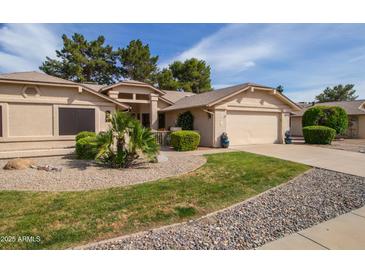 Charming single-story home with desert landscaping, lush greenery, and a two-car garage at 13731 W Greenview Dr, Sun City West, AZ 85375