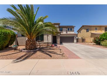 Two-story home with desert landscaping, brick accents, and a large palm tree in the front yard at 1446 E Douglas St, Casa Grande, AZ 85122