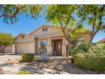 Charming single-story home featuring desert landscaping, a covered entry, and attached two car garage at 2409 W Red Range Way, Phoenix, AZ 85085