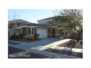 Beautiful two story home featuring a manicured front yard and an attached two car garage at 26022 N Sandstone Way, Surprise, AZ 85387