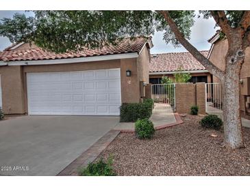 Charming home featuring a white garage door, terra cotta tile roof, and tasteful landscaping at 3510 E Hampton Ave # 74, Mesa, AZ 85204