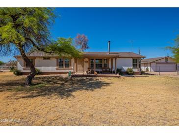 Charming single-story home with a welcoming front porch and a spacious front yard at 3738 E Hash Knife Draw Rd, Queen Creek, AZ 85140