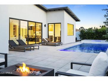 Modern backyard featuring a pool, lounge chairs, and a fire pit with views into the home at 4002 N 33Rd Pl, Phoenix, AZ 85018