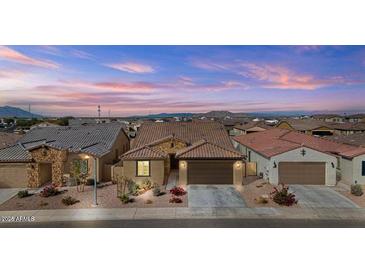 Charming home with desert landscaping, stone accents, and a tile roof under a lovely sky at 40990 W Agave Rd, Maricopa, AZ 85138
