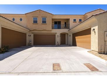 Beige two-story home with brown garages, balcony, and a spacious concrete driveway at 1367 S Country Club Dr # 1167, Mesa, AZ 85210