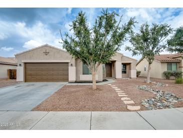 Charming single-story home featuring a two-car garage and desert landscaping in front at 14752 W Evans Dr, Surprise, AZ 85379