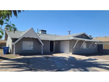 Charming single-story home featuring a well-maintained front yard and attached garage with a curved driveway at 2908 N 53Rd Ln, Phoenix, AZ 85031