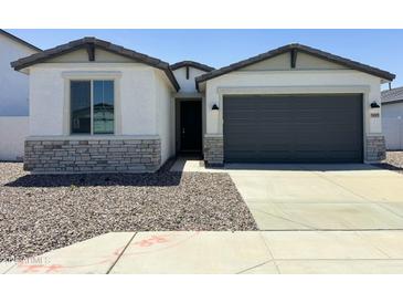 Charming single-Gathering home featuring stone accents, a two-car garage, and a well-maintained gravel yard at 5019 W Walatowa St, Laveen, AZ 85339