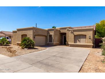 Single-story home with a two-car garage, desert landscaping and a concrete driveway at 870 E Megan St, Gilbert, AZ 85295