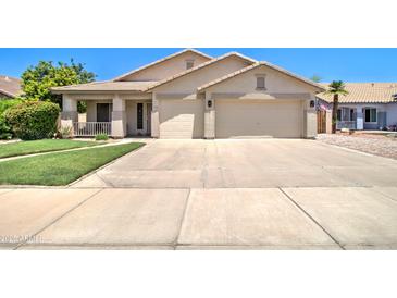 Charming single-story home featuring a two-car garage and well-manicured front yard at 14298 W Amelia Ave, Goodyear, AZ 85395