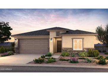 Charming single-story home featuring a two-car garage, stone accents, and desert landscaping at 17746 W Getty Dr, Goodyear, AZ 85338