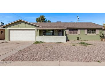 Charming single-story home featuring a desert landscape and a convenient two-car garage at 4004 W Myrtle Ave, Phoenix, AZ 85051