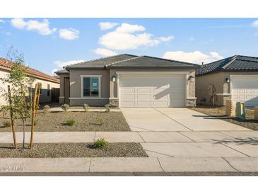 Charming single-story home with a two-car garage and low-maintenance desert landscaping in the front yard at 42875 W Vincent Dr, Maricopa, AZ 85138