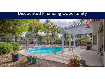 Backyard view featuring a sparkling pool, lush landscaping, patio with pergola and outdoor seating at 835 W Beechnut Dr, Chandler, AZ 85248