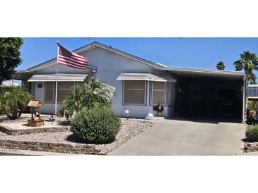 Charming single-story home with a covered carport and well-maintained front yard with desert landscaping at 2400 E Baseline Ave # 169, Apache Junction, AZ 85119