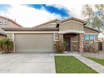 Charming single-story home featuring brick accents, a two-car garage, and manicured landscaping at 28232 N Abby Cir, San Tan Valley, AZ 85143