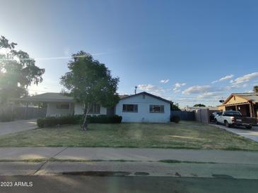 Charming single-story home featuring a spacious front yard, mature tree, and a covered carport at 3208 W Bloomfield Rd, Phoenix, AZ 85029