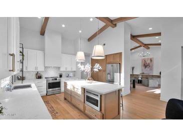 Bright, modern kitchen with an island, stainless steel appliances, and wooden beam accents at 5103 E Juniper Ave, Scottsdale, AZ 85254