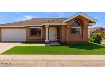 Charming single-story home featuring a manicured lawn and attached two-car garage at 915 E Annette Dr, Phoenix, AZ 85022
