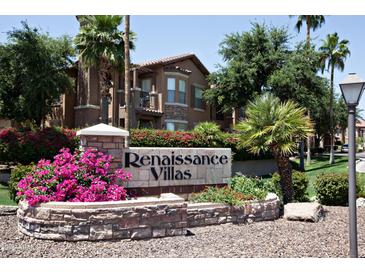 Renaissance Villas community sign with lush landscaping and a view of the multi-story building with stone accents at 14250 W Wigwam Blvd # 522, Litchfield Park, AZ 85340