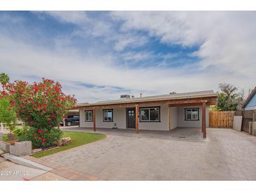 Inviting single-Gathering home with a spacious front yard, covered parking, manicured lawn, and blooming flowers at 1861 N 63Rd Ave, Phoenix, AZ 85035