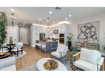 Bright living room featuring modern furnishings, an open floor plan, and a stylish kitchen with a center island at 1910 W Desert Hollow Dr, Phoenix, AZ 85085
