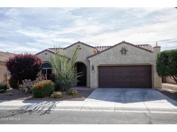 Charming single-story home with stucco and a tile roof, complemented by desert landscaping at 21883 N 263Rd Dr, Buckeye, AZ 85396