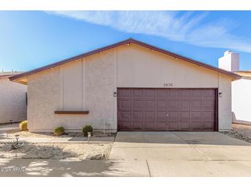 Charming single-story home showcasing a well-maintained two-car garage, xeriscaping, and a neutral color palette at 2635 W Hearn Rd, Phoenix, AZ 85023